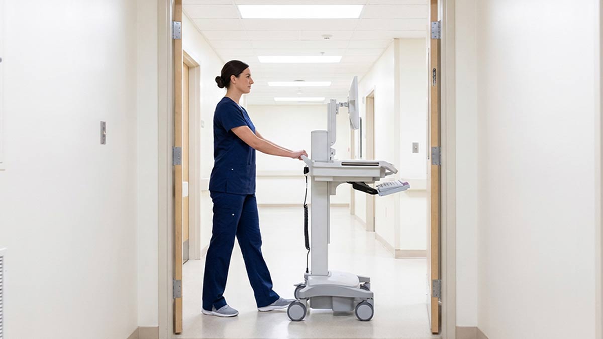 medical-computer-carts-on-wheels Nurse walking with medical computer carts on wheels